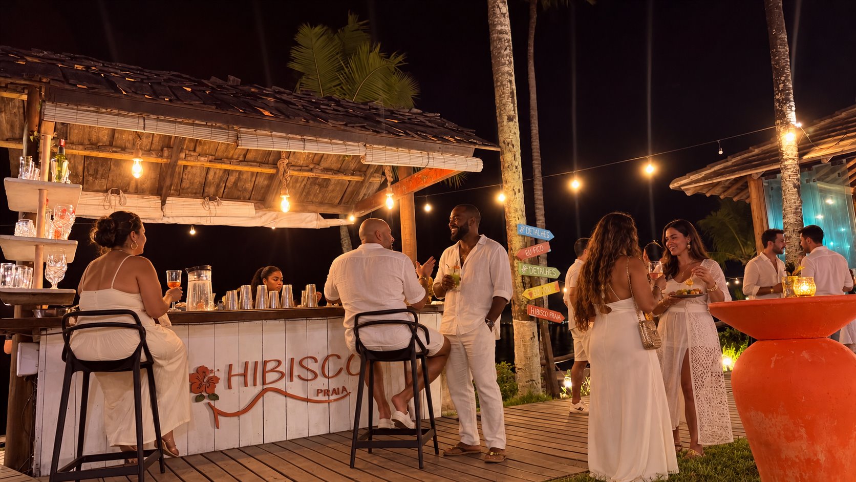 Convidados vestidos de branco reunidos no bar do Hibisco Praia