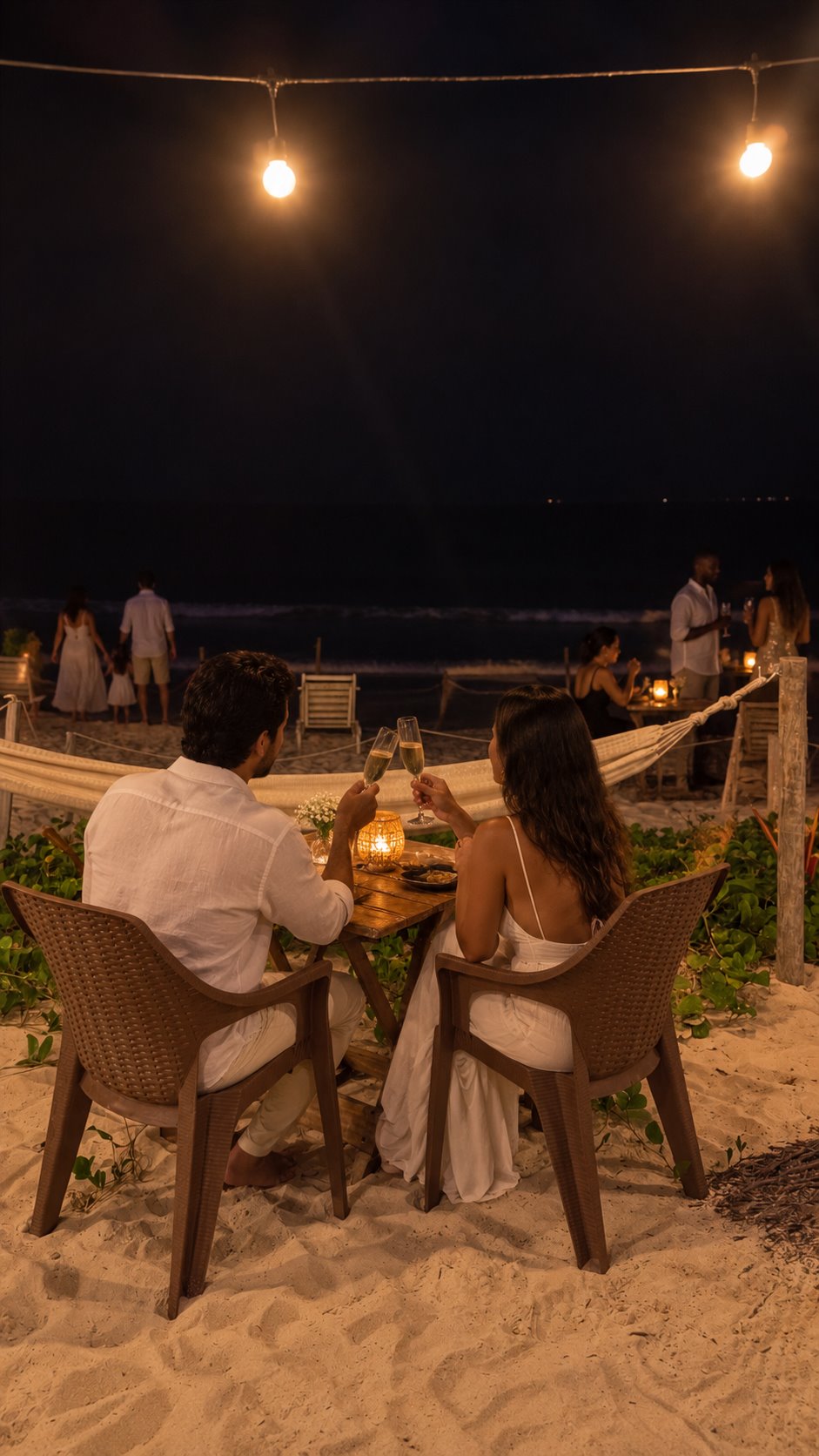 Casal brindando diante do mar à noite