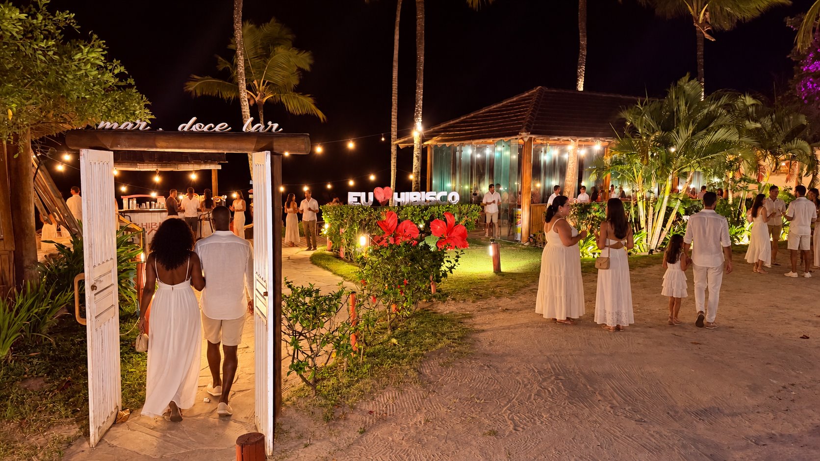 Convidados chegando ao Hibisco Praia iluminado à noite